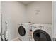 This laundry room features a tile floor, a washer, and a dryer at 5291 Meredrew Ln, St Cloud, FL 34771