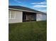View of the home's screened-in lanai, offering outdoor living space overlooking the green, grassy backyard at 567 Viceroy Ct, Kissimmee, FL 34758