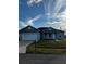 Inviting single-story home featuring a two-car garage, green lawn, and neutral-tone exterior under a blue sky at 567 Viceroy Ct, Kissimmee, FL 34758