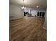 Open-concept living space featuring wood-look floors, recessed lighting, and a view into the modern kitchen at 567 Viceroy Ct, Kissimmee, FL 34758