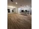 Open-concept living room with wood-look tile flooring, bright windows and a modern kitchen at 567 Viceroy Ct, Kissimmee, FL 34758