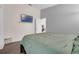 Cozy bedroom with soft green bedding, a wall-mounted TV, and an adjacent doorway at 5729 Norman H Cutson Dr, Orlando, FL 32821