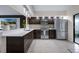 A kitchen with stainless steel appliances, dark wood cabinets, and bright quartz countertops at 5729 Norman H Cutson Dr, Orlando, FL 32821