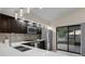 An eat-in kitchen with stainless steel appliances, quartz countertops, dark cabinets, and a sliding glass door to the patio at 5729 Norman H Cutson Dr, Orlando, FL 32821