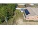 Aerial view of a spacious backyard featuring a storage shed, a greenhouse, and solar panels on the roof at 7135 Sw 129Th St, Ocala, FL 34473