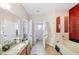 Spacious bathroom with dual sinks, a tub, and a separate toilet room for added privacy at 7135 Sw 129Th St, Ocala, FL 34473