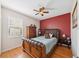 Cozy bedroom showcasing a decorative headboard, hardwood floors, and ample natural light at 7135 Sw 129Th St, Ocala, FL 34473