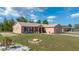 Attractive single-story home featuring a lush green lawn, driveway, and complemented by a serene, tree-lined backdrop at 7135 Sw 129Th St, Ocala, FL 34473