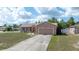 Inviting single-story home with a well-manicured lawn, a concrete driveway, and charming curb appeal on a sunny day at 7135 Sw 129Th St, Ocala, FL 34473