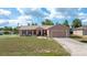 Charming single-story home with a well-maintained lawn, mature trees, and a two-car garage on a sunny day at 7135 Sw 129Th St, Ocala, FL 34473