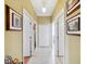 Hallway with multiple doorways, neutral walls, and framed artwork adding visual interest at 7135 Sw 129Th St, Ocala, FL 34473