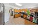 Functional kitchen equipped with wooden cabinets, granite countertops, modern appliances, and tile flooring at 7135 Sw 129Th St, Ocala, FL 34473