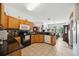 Well-lit kitchen featuring wood cabinets, granite countertops, modern appliances, and tile flooring at 7135 Sw 129Th St, Ocala, FL 34473