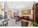 Open living room with tile flooring, a chandelier, comfortable leather furniture, and a view to the entryway at 7135 Sw 129Th St, Ocala, FL 34473