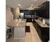 Modern kitchen with dark cabinets, stainless steel appliances, and a large granite island at 7629 Ripplepointe Way, Windermere, FL 34786