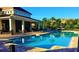 Community pool featuring clear blue water, brick pavers, covered seating area, and lush landscaping at 7629 Ripplepointe Way, Windermere, FL 34786