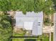 Aerial view of a home highlighting its roof, driveway, and surrounding green landscape at 7679 Bent Bow Trl, Winter Park, FL 32792