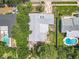 An aerial shot showcasing the home, roof, yards and neighboring pools within a lush community at 7679 Bent Bow Trl, Winter Park, FL 32792