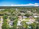 Aerial view of a neighborhood with a home, surrounded by mature trees and a tranquil lake at 7679 Bent Bow Trl, Winter Park, FL 32792