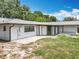 A spacious backyard featuring grass, a paved patio, and the exterior of the home at 7679 Bent Bow Trl, Winter Park, FL 32792
