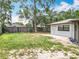 A fenced backyard with a mix of green grass and exposed dirt, featuring a large tree at 7679 Bent Bow Trl, Winter Park, FL 32792