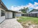 A backyard featuring green grass, a brick patio, and a wooden fence for privacy at 7679 Bent Bow Trl, Winter Park, FL 32792