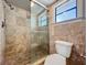 Bathroom featuring a tiled shower with glass door and updated toilet at 7679 Bent Bow Trl, Winter Park, FL 32792