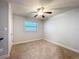A neutral bedroom includes a ceiling fan and natural light from a window at 7679 Bent Bow Trl, Winter Park, FL 32792