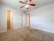 The carpeted bedroom features a ceiling fan, closet, and attached bathroom at 7679 Bent Bow Trl, Winter Park, FL 32792