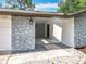 Covered carport featuring stone accent wall, updated lighting, and access to the main residence at 7679 Bent Bow Trl, Winter Park, FL 32792