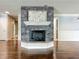 Close-up of a stone fireplace with a white mantel and hearth, and hardwood floors at 7679 Bent Bow Trl, Winter Park, FL 32792