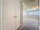 Hallway showing closet doors and a bedroom with natural light at 7679 Bent Bow Trl, Winter Park, FL 32792