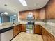 Stylish kitchen with stainless steel appliances, granite countertops, and ample cabinet space at 7679 Bent Bow Trl, Winter Park, FL 32792