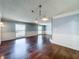 Bright living room featuring two windows, gleaming hardwood floors, and stylish wainscoting at 7679 Bent Bow Trl, Winter Park, FL 32792
