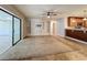 Living room featuring carpet and tile flooring, with built-in shelves and a view into the kitchen at 7679 Bent Bow Trl, Winter Park, FL 32792