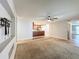 Living room with carpet, tile floor, and an opening view into the kitchen at 7679 Bent Bow Trl, Winter Park, FL 32792