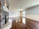 Spacious living room with hardwood floors, wainscoting, and a stone fireplace as a focal point at 7679 Bent Bow Trl, Winter Park, FL 32792