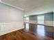 Bright living room showcasing hardwood floors, large windows, and wainscoting at 7679 Bent Bow Trl, Winter Park, FL 32792