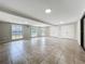 Bright living room featuring tile floors, recessed lighting, and multiple windows overlooking the landscaped backyard at 7679 Bent Bow Trl, Winter Park, FL 32792