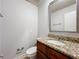 Half bathroom with decorative mirror and granite vanity at 7679 Bent Bow Trl, Winter Park, FL 32792