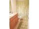 Functional bathroom with a wood vanity, and a patterned shower curtain at 7842 Holiday Isle Dr # 102, Belle Isle, FL 32812