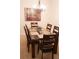 Formal dining room featuring a glass-top table, seating for six, and an elegant chandelier at 7842 Holiday Isle Dr # 102, Belle Isle, FL 32812