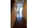 Inviting hallway with gleaming hardwood floors leading to sunlit rooms at 7842 Holiday Isle Dr # 102, Belle Isle, FL 32812