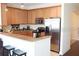 Well-equipped kitchen with stainless steel appliances, light wood cabinets, and a breakfast bar at 7842 Holiday Isle Dr # 102, Belle Isle, FL 32812