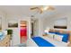 Bright bedroom featuring a bed with blue accents and an en-suite bathroom with a colorful shower curtain at 8520 La Isla Dr, Kissimmee, FL 34747