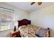Cozy bedroom features natural light from the window, with a ceiling fan adding to the room's comfort at 8520 La Isla Dr, Kissimmee, FL 34747