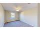 A well-lit bedroom features neutral carpet, a ceiling fan and a window with a view of the outdoors at 8520 La Isla Dr, Kissimmee, FL 34747