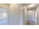 Well-lit hallway with neutral walls, carpet, and views into a bedroom with natural light at 8520 La Isla Dr, Kissimmee, FL 34747
