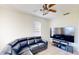 Cozy living room with a large TV, ceiling fan, and a comfortable leather sectional sofa at 8520 La Isla Dr, Kissimmee, FL 34747