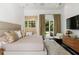 Bright bedroom with plush rug, luxurious pillows, ensuite bathroom, and access to outdoor space through French doors at 9743 Covent Garden Dr, Orlando, FL 32827